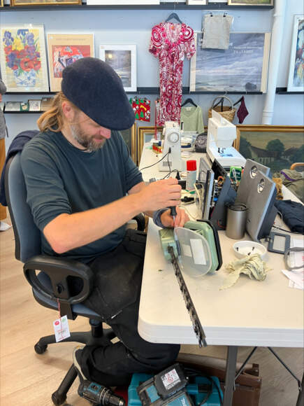 Bastian fra Klimabevægelsen reparerer her en lokalborgers hækkeklipper. Foto: Mai-Britt Hvam Krogh